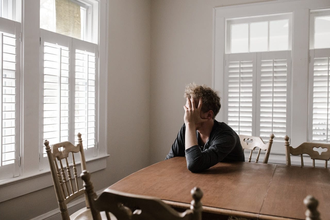 man leaning on wooden table